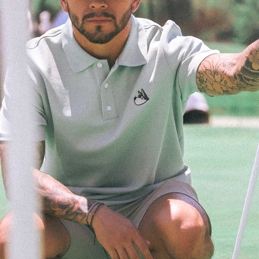 Man in a eucalyptus polo shirt and cap on a golf course