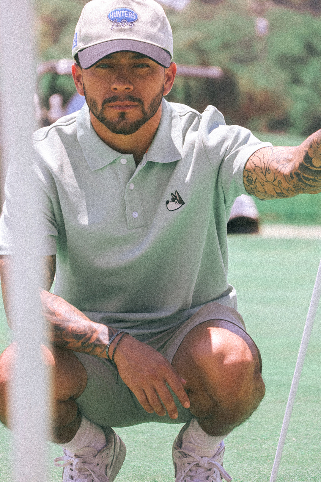 Man in a eucalyptus polo shirt and cap on a golf course
