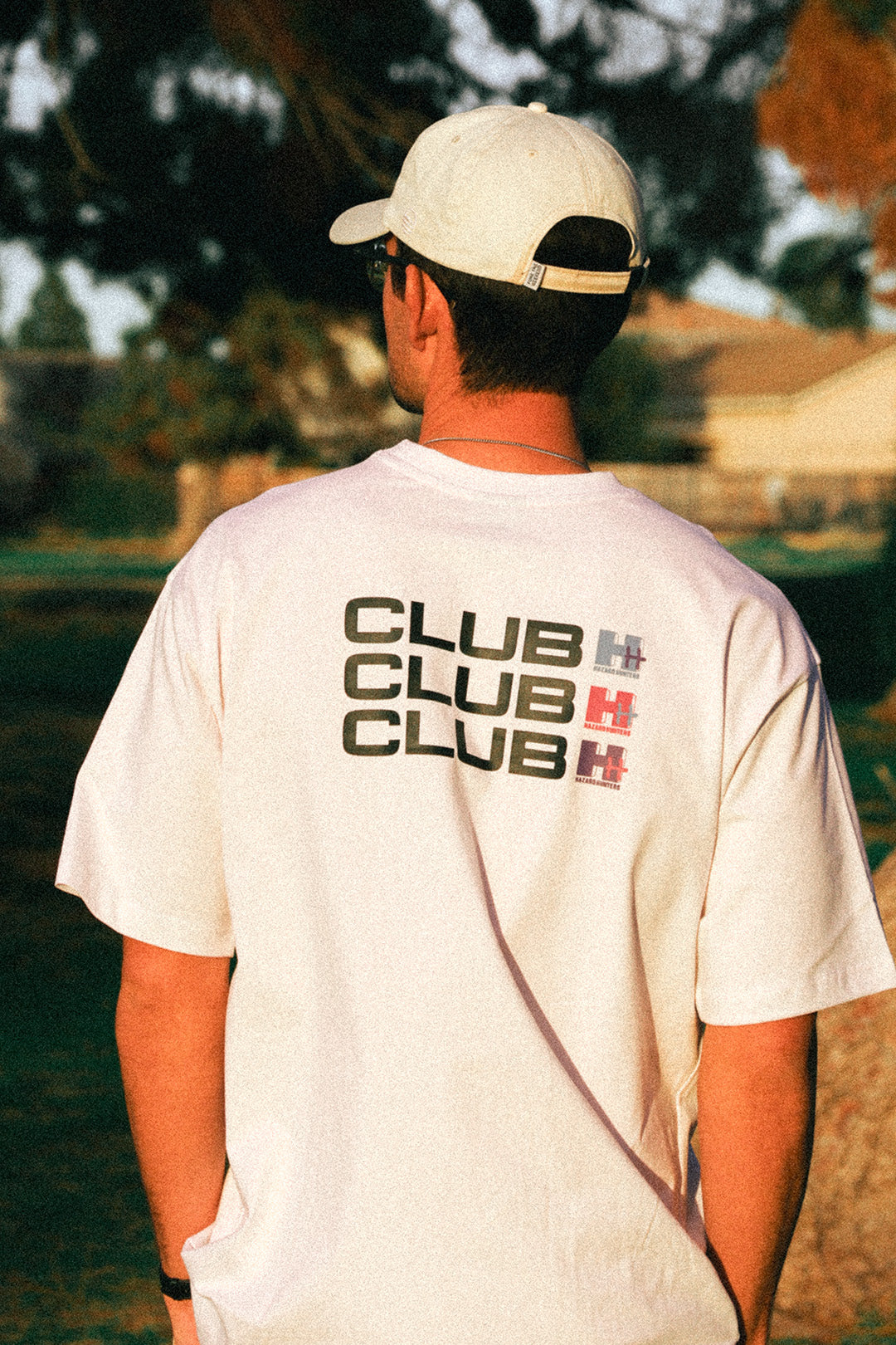 Man wearing white tshirt with Club HH on the back