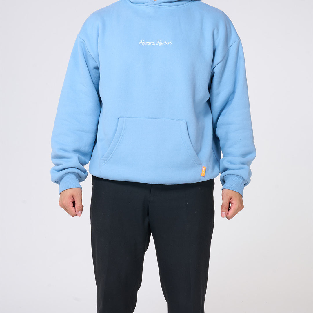 Person wearing a light blue hoodie with a brand logo on a white background