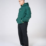 Person wearing a green hoodie and black pants on a white background