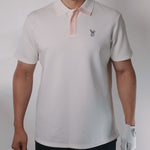 Person wearing a white polo shirt with a small logo on a plain background