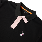 A black polo shirt with a white and pink embroidered bunkie emblem on the chest,  pink contrast on the button placket and collar, and a relaxed fit.
