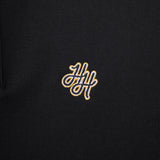 Black polo shirt with gold embroidered logo on a black background