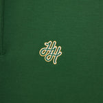 Green polo shirt with a gold embroidered logo on a close-up view