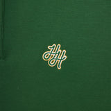 Green polo shirt with a gold embroidered logo on a close-up view