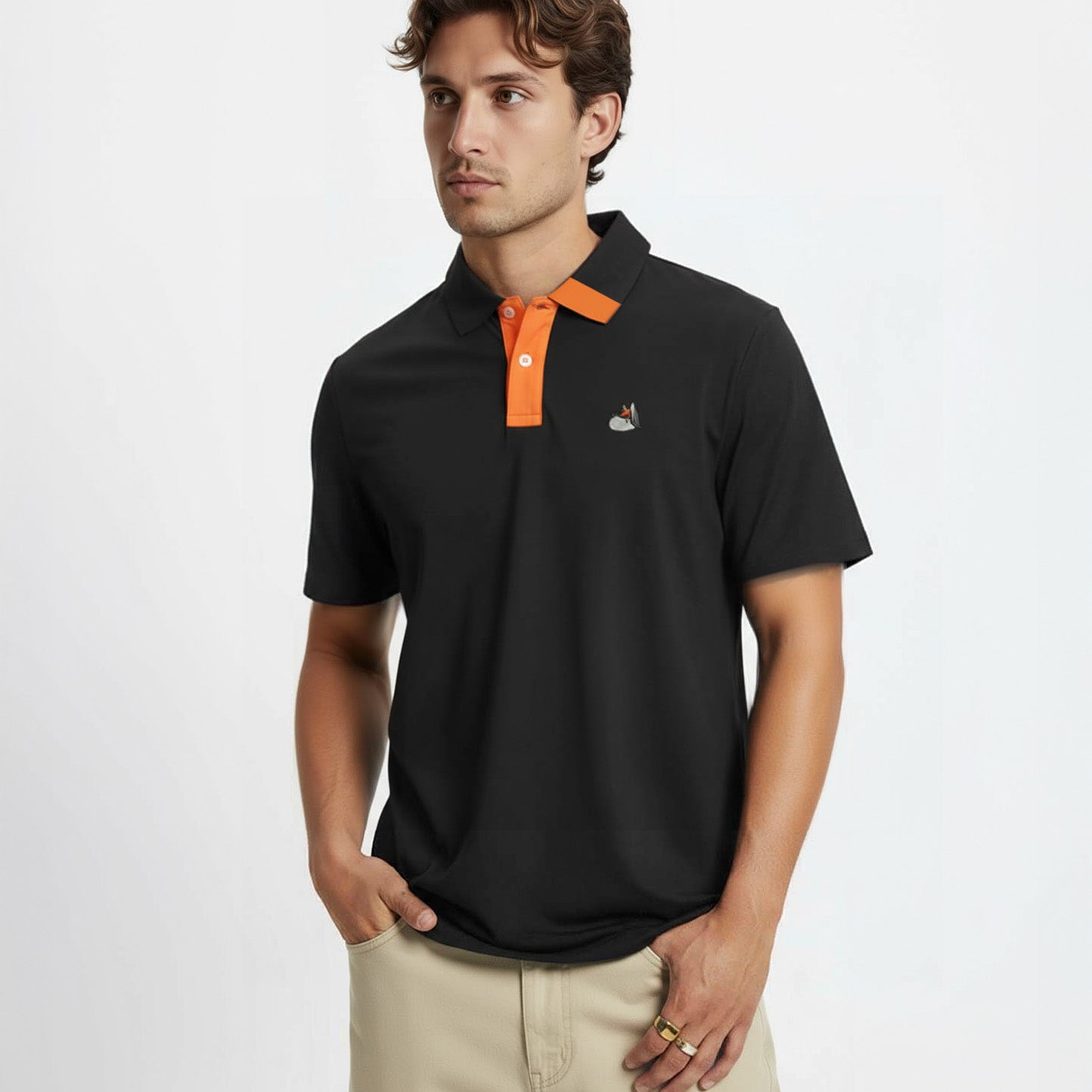 Man wearing a black polo shirt with orange accents on a white background